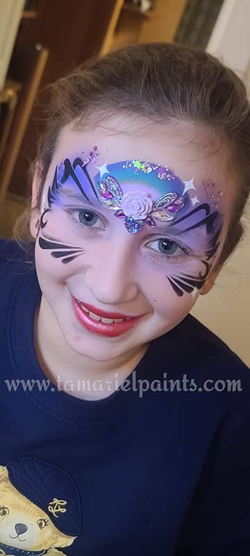 A girl with colorful butterfly and flower airbrush face paint