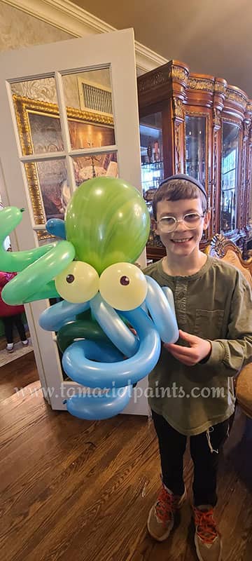 A child holds a twisted balloon octopus